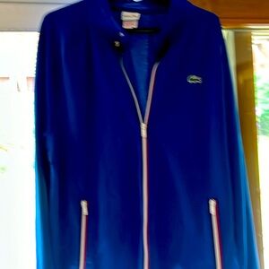 Track jacket by Lacoste. Bright blue with red trim